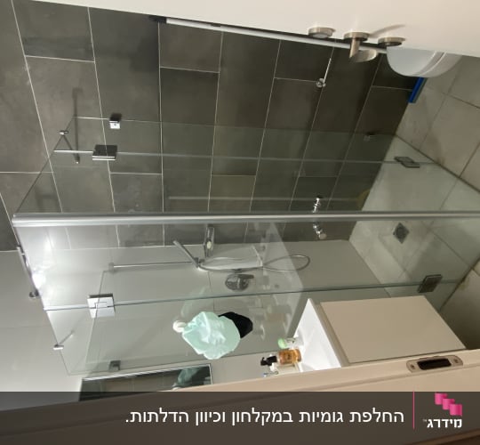 מקלחון זכוכית פינתי מותקן בחדר רחצה